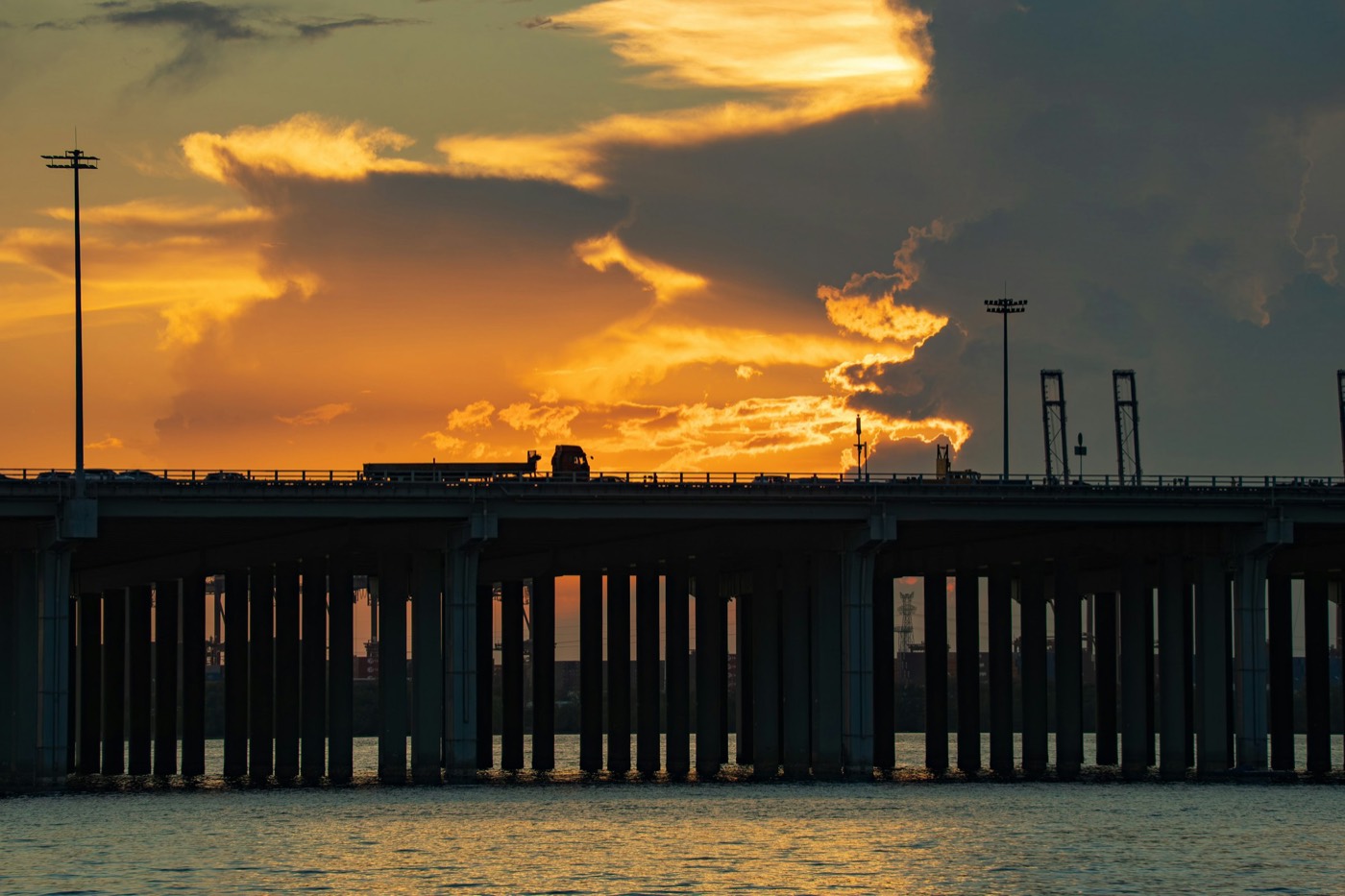 Caminhão atravessando ponte ao pôr do sol